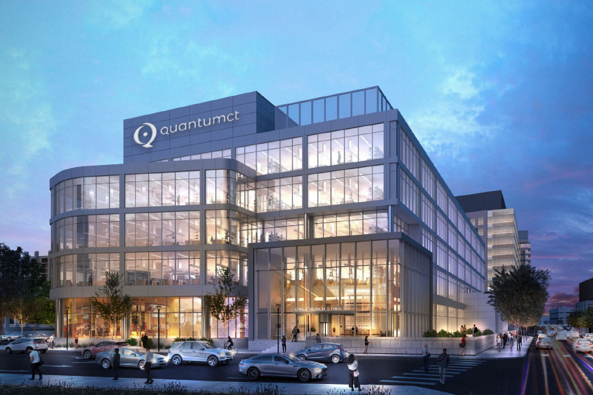 A man with a mask on working in a lab on quantum computer hardware.